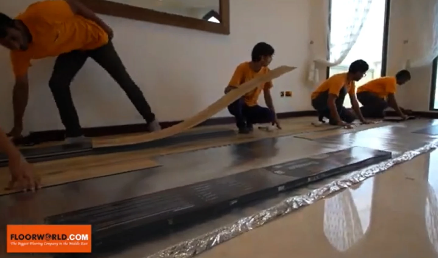 image composite of floorworld team installing a floor with floorworld logo in corner